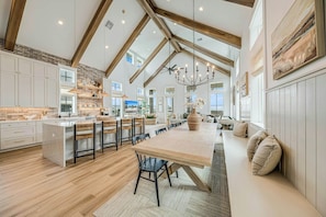 A spacious kitchen with high ceilings, exposed beams, and a large island with bar seating. - Palmilla Beach Resort-260 Sunrise Avenue (Port Aransas)