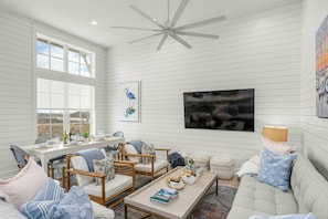 A spacious room with a dining area, seating, and a ceiling fan. - Palmilla Beach Resort-280 Sunrise Avenue (Port Aransas)
