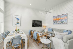 A dining area with a white table set for six, surrounded by wicker chairs. - Palmilla Beach Resort-280 Sunrise Avenue (Port Aransas)