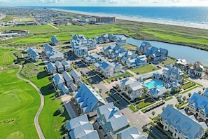 A coastal residential area with multiple houses, a golf course, and a large body of water. - Palmilla Beach Resort-292 Sunrise Avenue (Port Aransas)