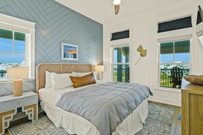 Ein Schlafzimmer mit Bett, Nachttischen, Blick auf die Stadt und einer Ziegelsteinmuster-Decke.