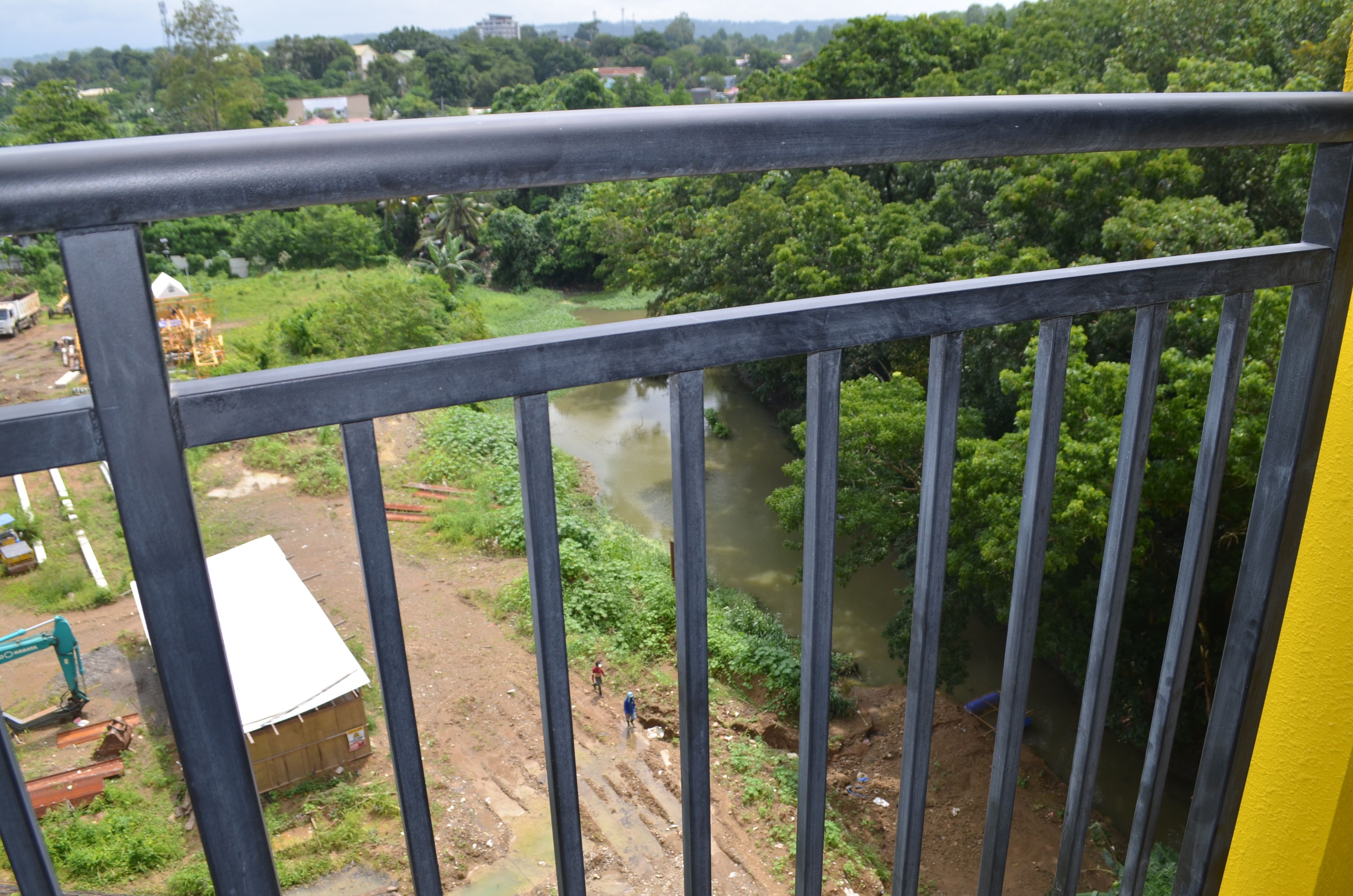 Ein Fluss mit dichter Vegetation und einer Baustelle im Vordergrund.