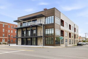 A modern building with a flat roof, large windows, and a visible street corner.