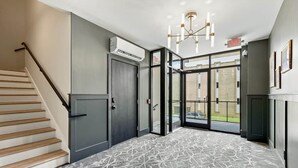 A hotel lobby with a staircase, a door, and a patterned carpet. - The Oaks · 2 Bedroom · 2 Bath · 1400SF (Owensboro)