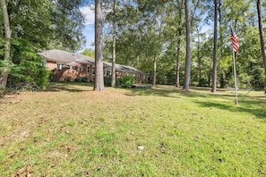 A residential property with a brick house, a lawn, and a hammock. - Laney’s Lake Retreat (Northport)