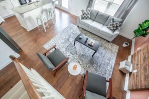 Una sala moderna con un sofá gris, una mesa de centro y una alfombra estampada.