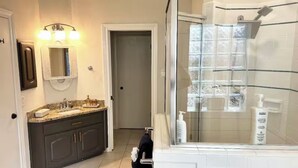 A bathroom with a glass-enclosed shower, a sink with a vanity, and a mirror. - The Berg - 5 min. From Six Flags, La Cantera & the Rim (San Antonio)