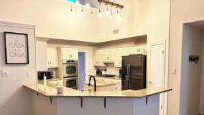 A modern kitchen with a central island, built-in appliances, and a pendant light fixture. - The Berg - 5 min. From Six Flags, La Cantera & the Rim (San Antonio)
