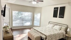 A bedroom with a bed, a bench, a ceiling fan, and two wall-mounted decorations. - The Berg - 5 min. From Six Flags, La Cantera & the Rim (San Antonio)