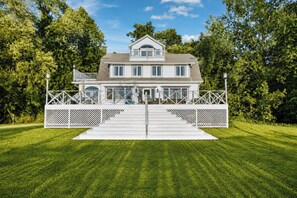 A two-story house with a front porch and a white fence. - Lake Michigan Retreat | Private Beach & Lawn (Coloma)