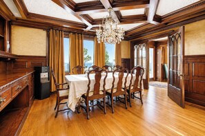 Ein Esszimmer mit Holztisch, Stühlen und einer Chandelier.