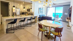 Een moderne keuken met een centraal eiland, barkrukken en hanglampen.