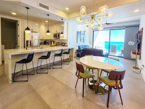 A modern kitchen with a central island, bar stools, and pendant lighting. - Ocean-View Las Palomas 9th floor 1BR  Luxury Condo Phase II Closest to Beach (Puerto Peñasco)