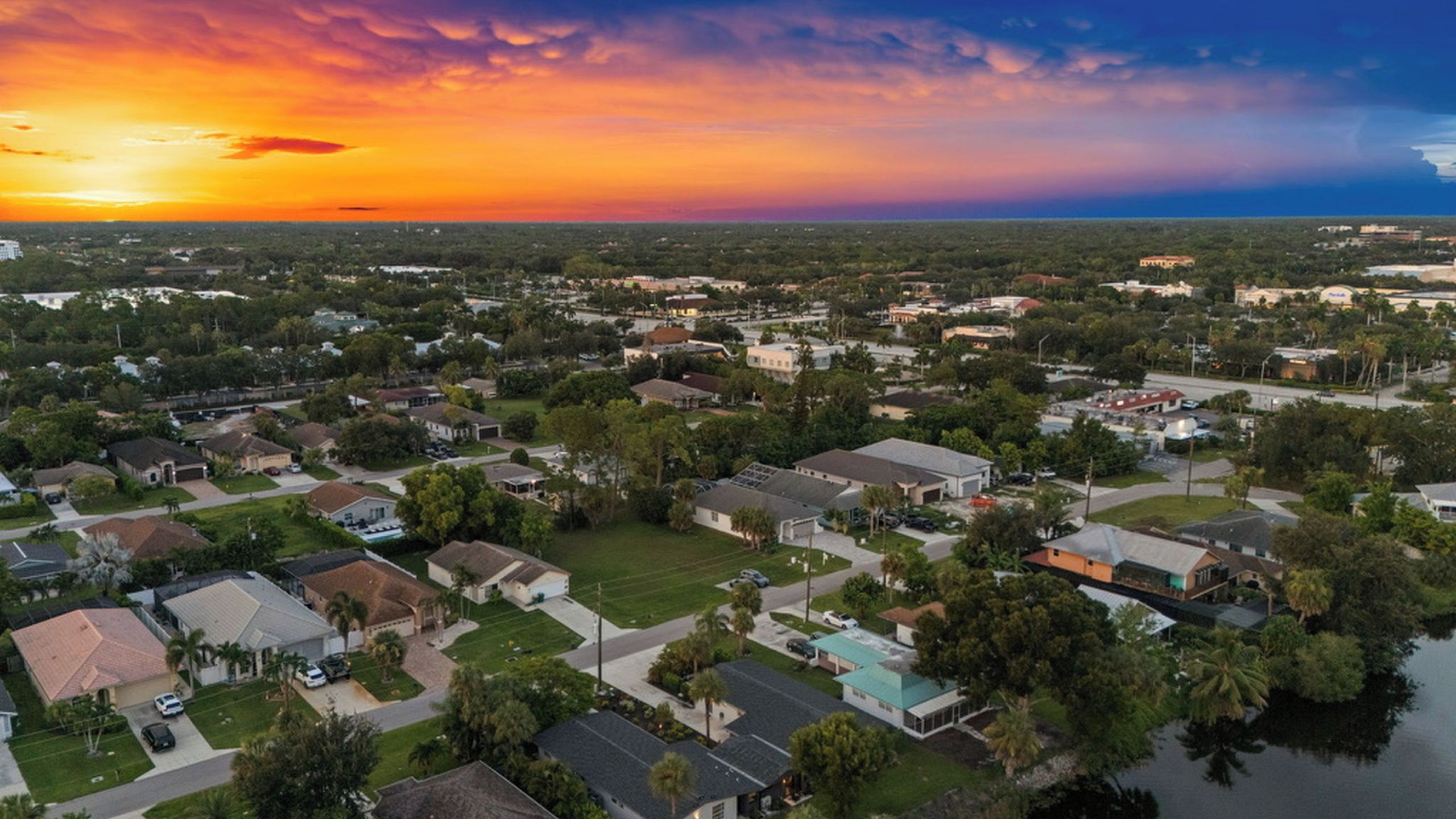 A residential area with houses, streets, and a body of water.