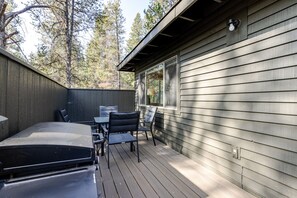 Una terrazza con barbecue, sedie e tavolo.