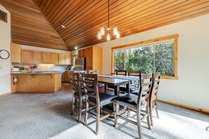 Un'ampia cucina con mobili in legno, un'isola centrale e un'area pranzo con un tavolo e sedie.