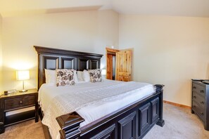 A bedroom with a large bed, dark wooden headboard, bedside tables, and a wardrobe. - 2 Sandhill - Family-Friendly Sunriver Retreat Near Fort Rock Park with 8 SHARC Passes (Sunriver)