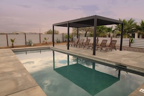 A swimming pool with a covered seating area and lounge chairs. - Sun Mesa Sanctuary · Pickleball, Pool, Sauna (Joshua Tree)