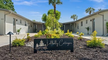 A sign for 'Molly Cottages' with a landscaped garden in front.