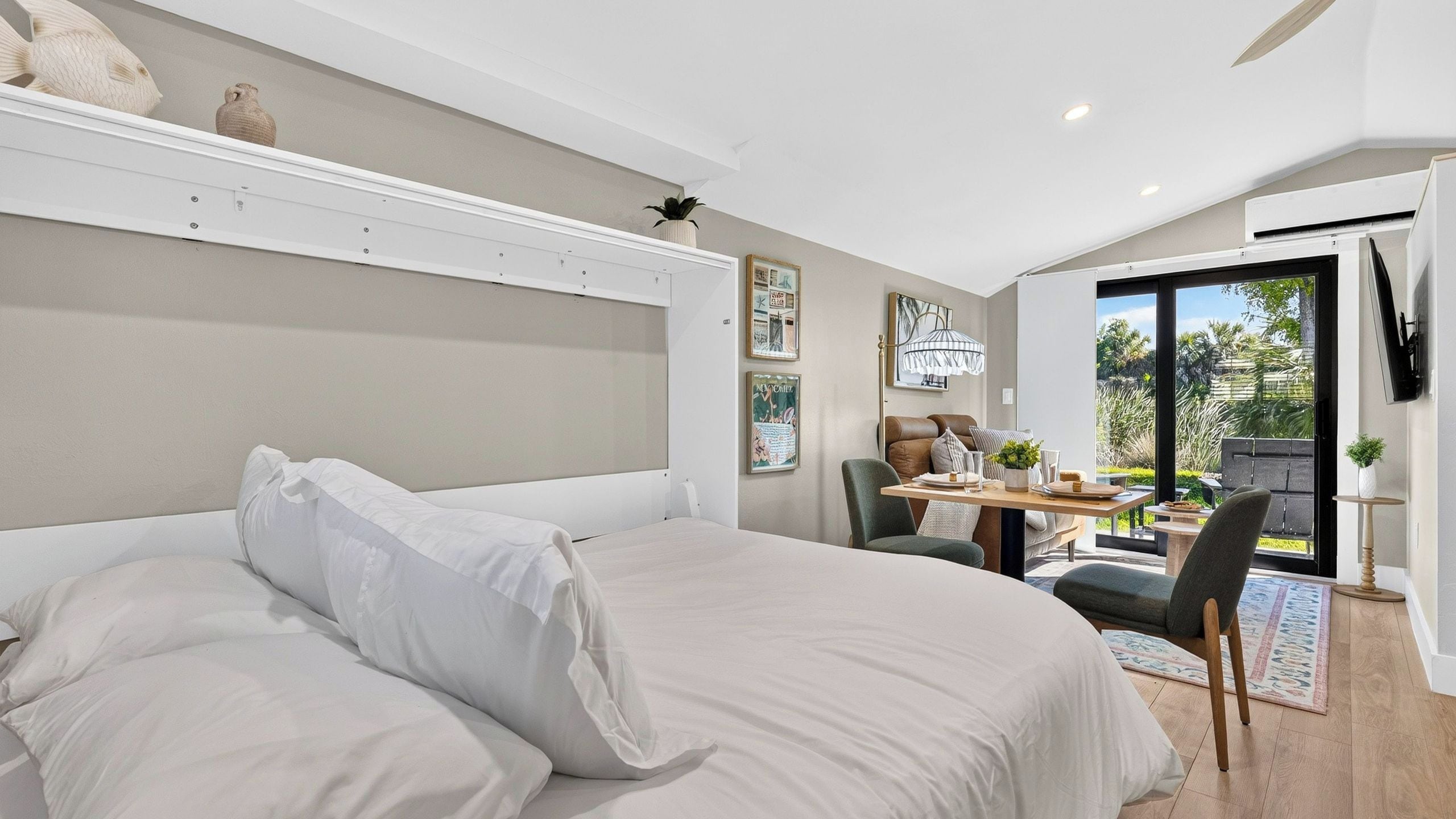 Une chambre moderne avec un grand lit, un bureau et une vue sur l’extérieur.