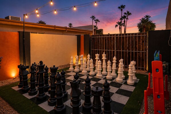 A chessboard set up outdoors with a sunset in the background.