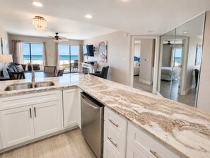 A modern kitchen with a marble countertop, white cabinetry, and a dishwasher. - 3BR Gulf Front condo with Amazing Views - sleeps 10 - Pet Friendly (Gulf Shores)