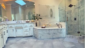 A modern bathroom with a marble vanity, a glass shower enclosure, and a large mirror. - Edmond Golf Escape -3BR • 3BA • 4 Beds (Edmond)