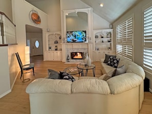 A living room with a fireplace, a television, and a sofa.