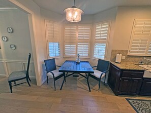 A dining area with a table and chairs, a chandelier, and a kitchen with a countertop and cabinets. - Edmond Golf Escape -3BR • 3BA • 4 Beds (Edmond)