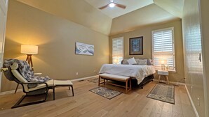 A bedroom with a bed, a chair, a ceiling fan, and two windows with blinds. - Edmond Golf Escape -3BR • 3BA • 4 Beds (Edmond)