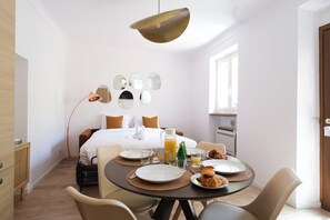 Ein modernes Hotelzimmer mit Bett, Frühstücksecke und Essbereich.