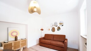 Una sala de estar moderna con un sofá marrón, un aparador de madera y una lámpara de pie.