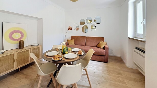 Un comedor moderno con una mesa redonda, sillas e iluminación colgante.