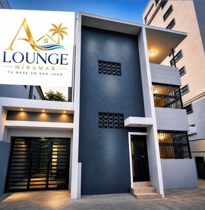 A modern building with a prominent sign for 'Lounge Miramar Tu Base En San Juan.' - A Lounge Miramar 2 SJ 2BR WITH AC Near Condado Lagoon, OSJ & Distrito T-Mobile (Miramar)