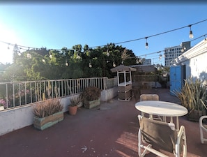 An outdoor patio area with a table and chairs, potted plants, and a pergola. - Villa Luna (Guadalajara)