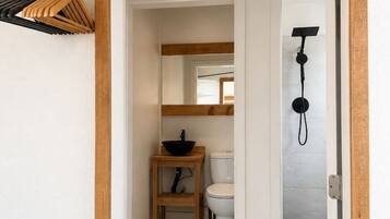 A bathroom with a toilet, sink, and shower.