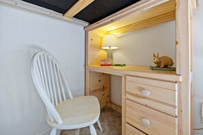 A wooden desk with a lamp, a chair, and a rabbit figurine. - Sandy Blue hot tub, and easy beach access. (Nags Head)