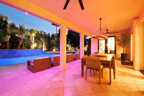 Eine Außenpatio mit Pool, Sitzgelegenheiten und Essbereich.