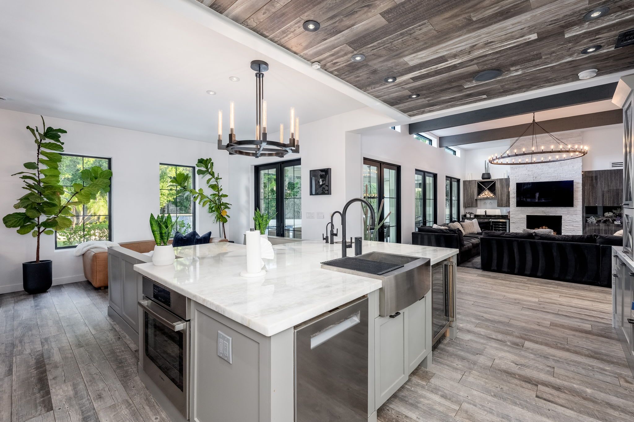 A modern kitchen with a central island, stainless steel appliances, and a large window providing natural light.
