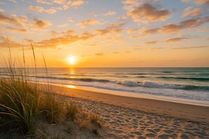 A beach with sand, grass, and waves. - 3BR, 2BA Magnolia Lakes condo in Myrtle Beach, sleeps 6. (Myrtle Beach)