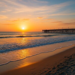 A beach with a pier extending into the water during sunset. - 3BR, 2BA Magnolia Lakes condo in Myrtle Beach, sleeps 6. (Myrtle Beach)