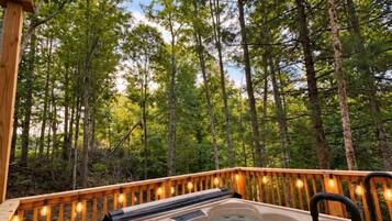 Un bain à remous sur une terrasse en bois, entouré d’arbres.