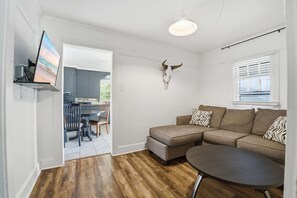 A modern living room with a sectional sofa, a round coffee table, and a mounted animal skull. - Cozy Private Room in Shared Home Near Downtown (Lafayette)