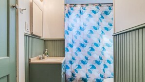Un bagno con tenda doccia, lavandino e water.