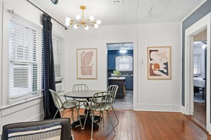 A dining area with a round table and chairs, a ceiling light fixture, and artwork on the walls. - Private Bedroom in 4BR Home (Lafayette)