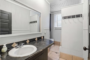 A bathroom with a white sink, a mirror, a towel rack, and a door. - Private Bedroom in 4BR Home (Lafayette)