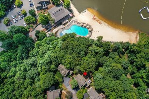 An aerial view of a residential area with a swimming pool, a beach, and a parking lot. - Bear Bluff - Game Room, Fire Table, Comfy Patio + Community Activities (Jasper)