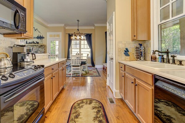 A kitchen with wooden cabinets, a stove, and a sink.