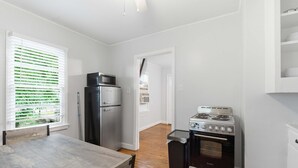 Une cuisine de taille réduite équipée d’un réfrigérateur, d’une cuisinière et d’une table à manger.