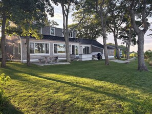 Een woonhuis met terras, zitplaatsen buiten en een barbecueplek.